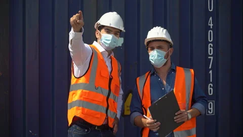 Foreman and engineer worker wearing protective face mask meeting and talking Stock Footage 156383361