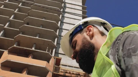 Foreman with a beard against the background of a house under construction Stock Footage 105677223