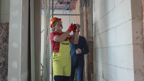 Foreman builder and construction worker in indoor apartment Stock Footage 133638687
