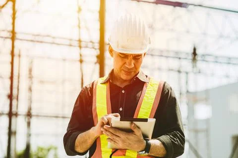 Foreman builder engineer worker using tablet computer to check building floor Stock Photos