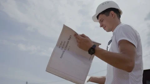 Foreman Builder looks at paper house project at the construction site Stock Footage 126707971