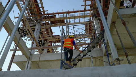 Foreman climbing scaffolding to inspect work on upper floor of building Stock Footage 169883351