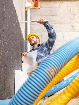 Foreman with construction plan and pocket rule checking construction work Stock Photos