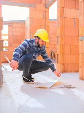 Foreman with construction plan and pocket rule at construction site Stock Photos