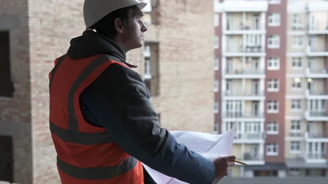 Foreman at a construction site high-rise building with drawings Stock Footage 143087398