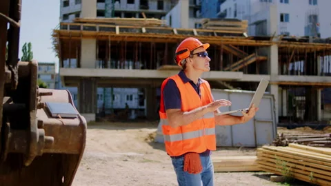 Foreman at construction site using laptop to check the plan of the build he Stock Footage 146599071