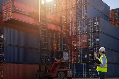 Foreman control loading Containers box to truck Stock Photos