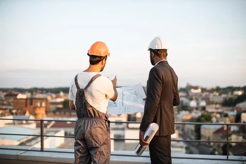 Foreman explaining drawings to international engineer 스톡 사진