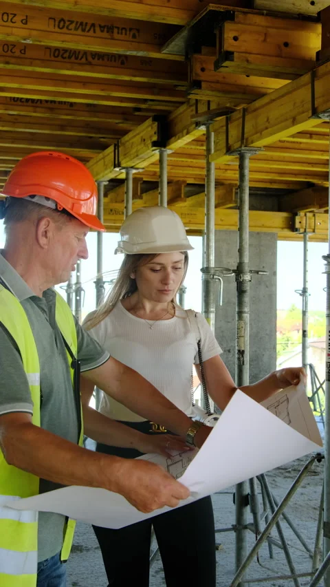 Foreman explains layout of building to female inspector Stock Footage 317622067