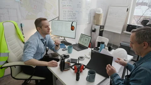 Foreman Giving Documents to Engineer in Construction Office Stock Footage 329621147