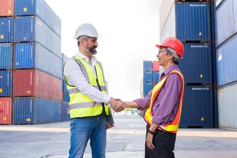 Foreman handshake engineer control loading Containers box from Cargo freight  Stock Photos