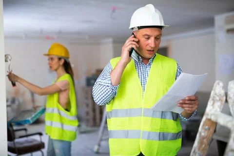 Foreman having work phone conversation at object Stock Photos