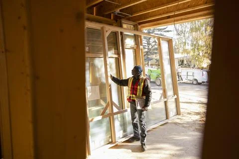 Foreman inspecting window frame at house under construction Stock Photos