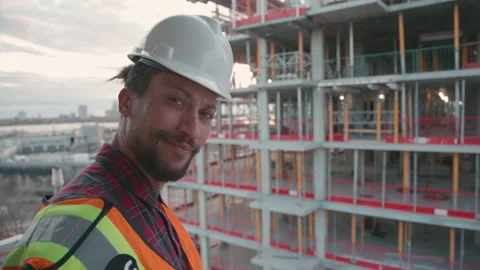 Foreman looking up at camera in the middle of a construction site Stock Footage 220747496
