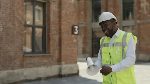 Foreman with megaphone dancing at construction site Stock Footage 201884323