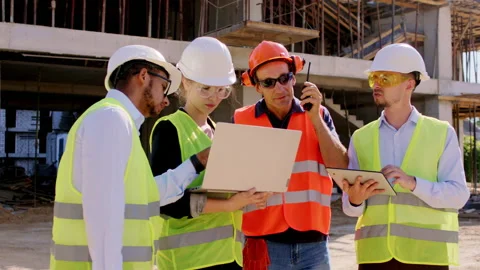 Foreman middle-aged and his group of diverse specialists analyzing the plan of Video stock 146601824