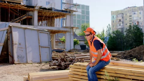 Foreman middle-aged have a nap at construction site at the lunch time he wake up Stock Footage 152078666