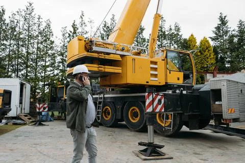 Foreman or architect on construction site talking by mobile phone Stock Photos