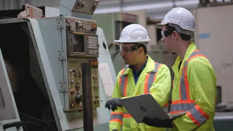 Foreman or engineer worker hold laptop and discuss with his co-worker Stock Footage 154466776