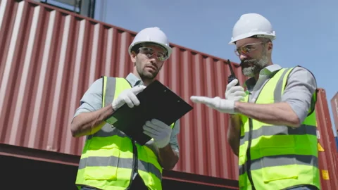 Foreman or engineer workers talk and discuss together during crane lift down Stock Footage 146470526
