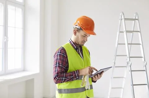 Foreman professional male worker using tablet computer to supervise personnel Stock Photos