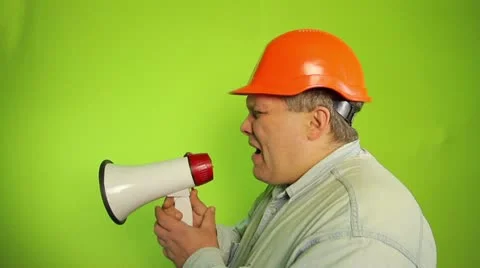 Foreman shouting into a megaphone on a green background Stock Footage 16706701