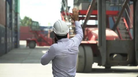 Foreman talking on the walkie-talkie control loading Containers box at wareho Stock Footage 145206224