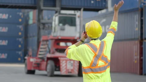 Foreman talking on the walkie-talkie control loading Containers box at warehouse Stock Footage 263651868