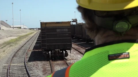 Foreman on train, passing train cars, cu, HD Stock Footage 123389199