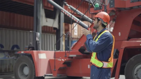 Foreman use walkie talkie to communicate and control staff in container area. Stock Footage 232505625