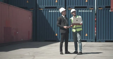 Foreman using laptop to explain about containers data to Asian businessman. Stock Footage 200987185