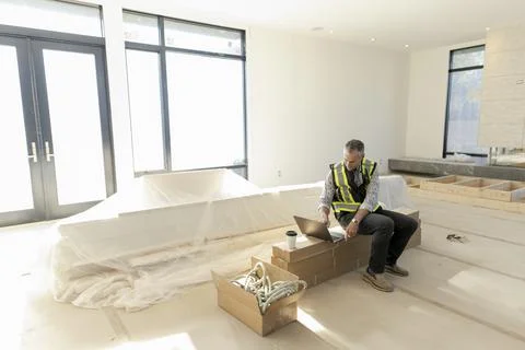 Foreman using laptop in house under construction Stock Photos
