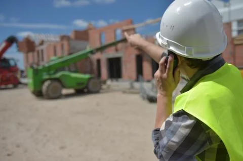 Foreman using walkie-talkie on construction site Foto stock