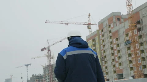 Foreman walking to the buildings under construction Stock Footage 86927863