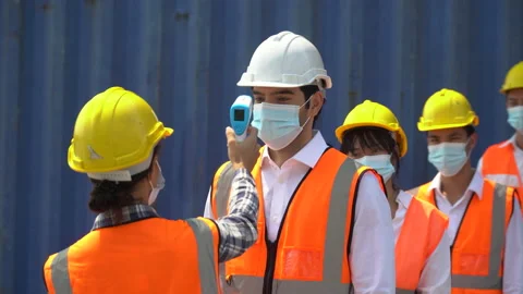 Foreman wear protective face mask scanning body temperature  to worker distan Stock Footage 159395327