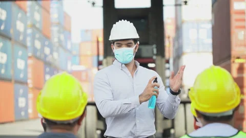 Foreman wear protective face show using hand sanitizer alcohol gel to worker Stock Footage 140277286
