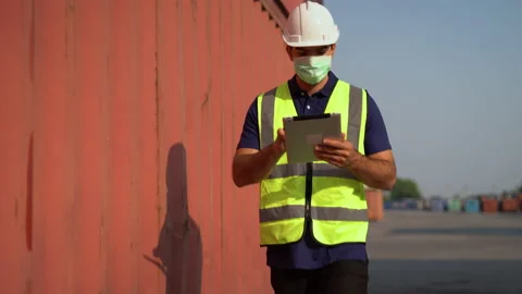 Foreman wearing face mask holding tablet computer walking to checking list of Stock Footage 157715308