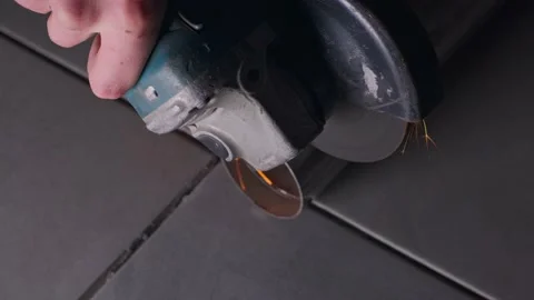 The foreman without gloves uses an angle grinder and cuts the stainless steel Stock Footage 152376465