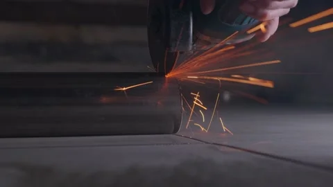 The foreman without gloves uses an angle grinder and cuts a stainless steel pipe Stock Footage 152376552