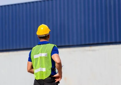 Foreman worker in hard hat and safety vest at containers cargo Stock Photos