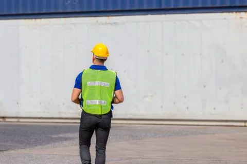 Foreman worker in hard hat and safety vest at containers cargo Photos