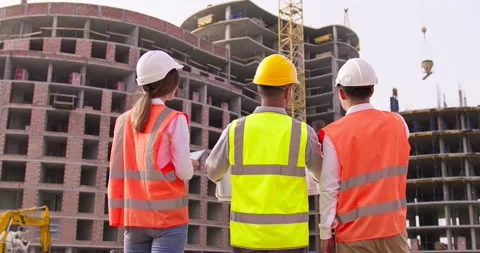 Foremen with tablet and blueprints and female architect standing in the Stock Footage 172288015