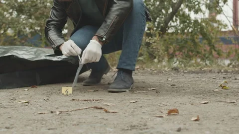 Forensic Expert Collecting Cigarette Stub at Murder Scene Stock Footage 255353104