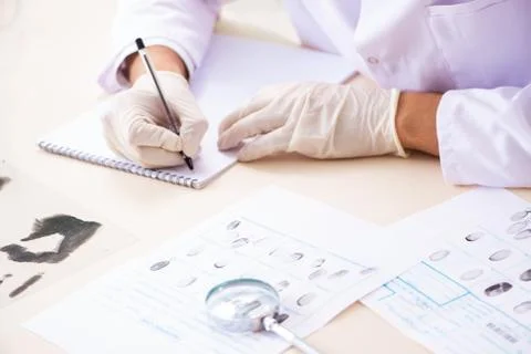Forensic expert studying fingerprints in the lab 写真素材