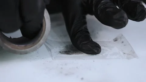 A forensic expert transfers a fingerprint from a surface to fingerprint tape. Stock Footage 316734190