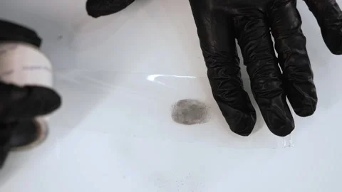 A forensic expert transfers a fingerprint from a surface to fingerprint tape. Stock Footage 316734264