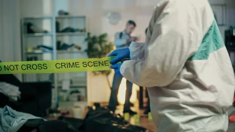 Forensic expert unrolling crime scene tape, securing perimeter, investigation Stock Footage 189471260