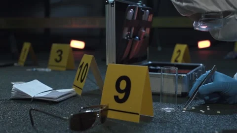 Forensic expert working at crime scene of drug dealer murder. Many evidence tags Stock Footage 286753915