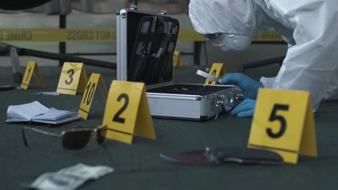 Forensic expert working at crime scene of drug dealer murder. Many evidence tags Video stock 286754669