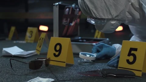 Forensic expert working at crime scene of drug dealer murder. Many evidence tags Video stock 286754969